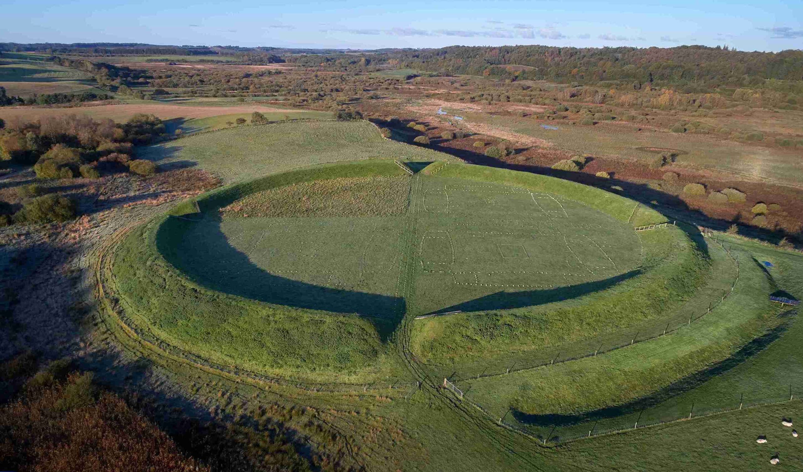 Fyrkat Viking-Age Ring Fortress: aerial view northeast over the fortress to reconstructed longhouse (with flag to right) and the wide valley of the river Onsild Å.